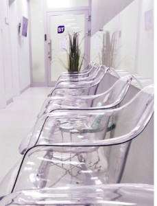 A line of transparent chairs in a waiting room.